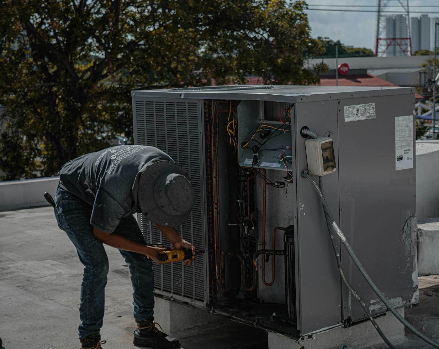 HVAC technician servicing rooftop AC unit